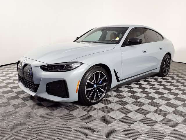 Front three-quarter view of a white 2023 BMW i4 eDrive40 in a showroom