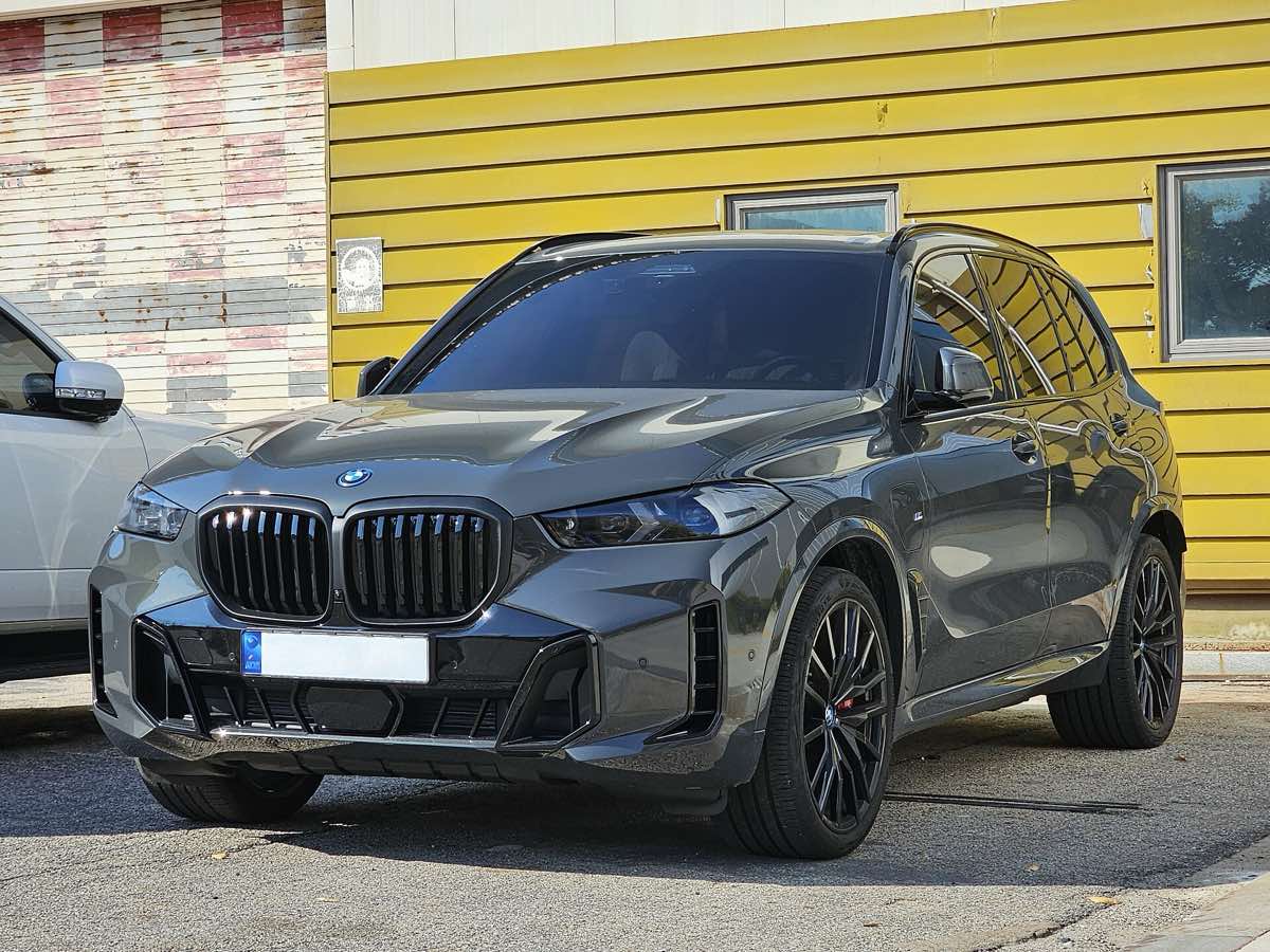 Front three-quarter view of a grey 2024 BMW X5 xDrive50e