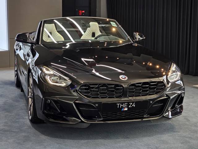 Front three-quarter view of a black 2022 BMW Z4 M40i roadster with the top down